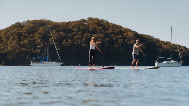 people stand up paddle boarding the calm water
