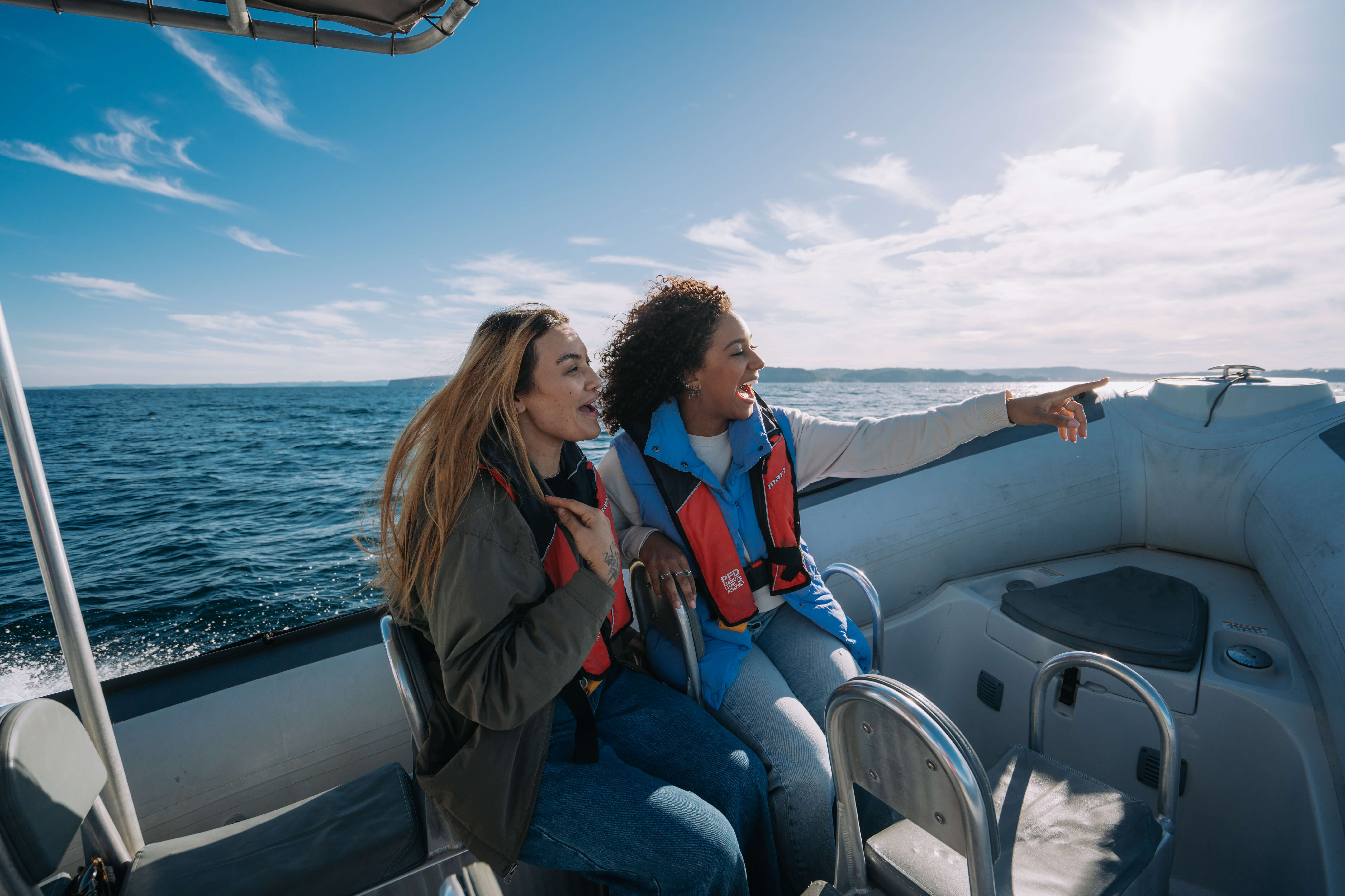 two tourists on eco boat whale watching in awe