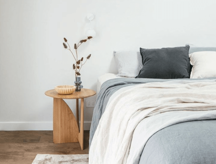 modern contemporary bed with grey bedspread and white blanket