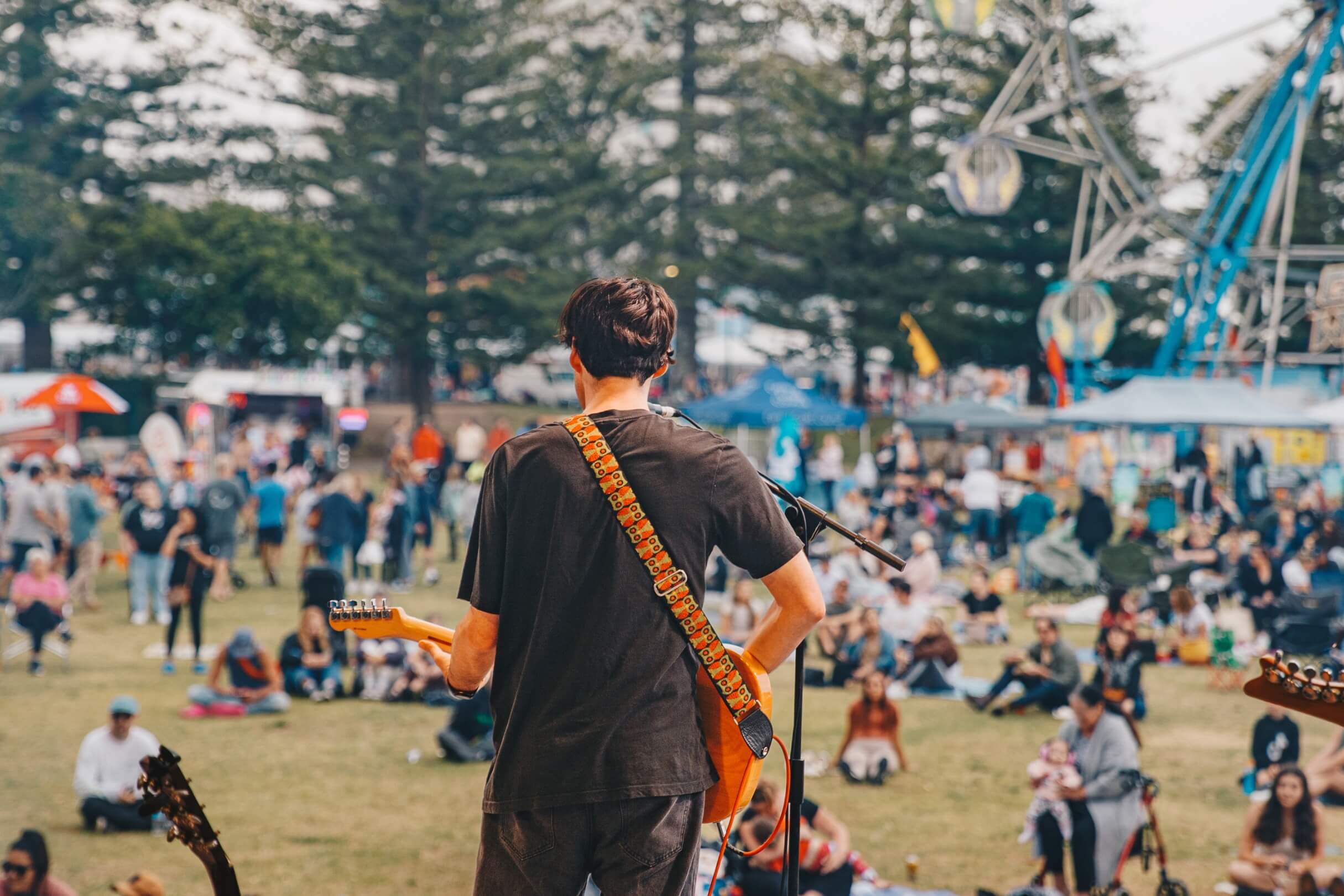 Musican playing guitar looking out from the stage