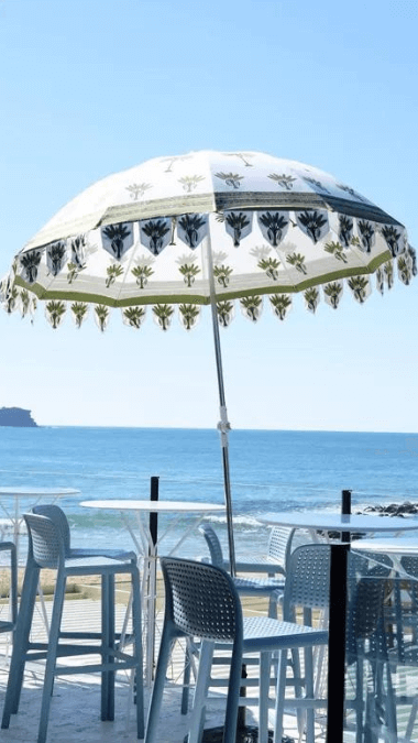 Bohemian beach umbrella with cafe seating with a stunning beach in the background