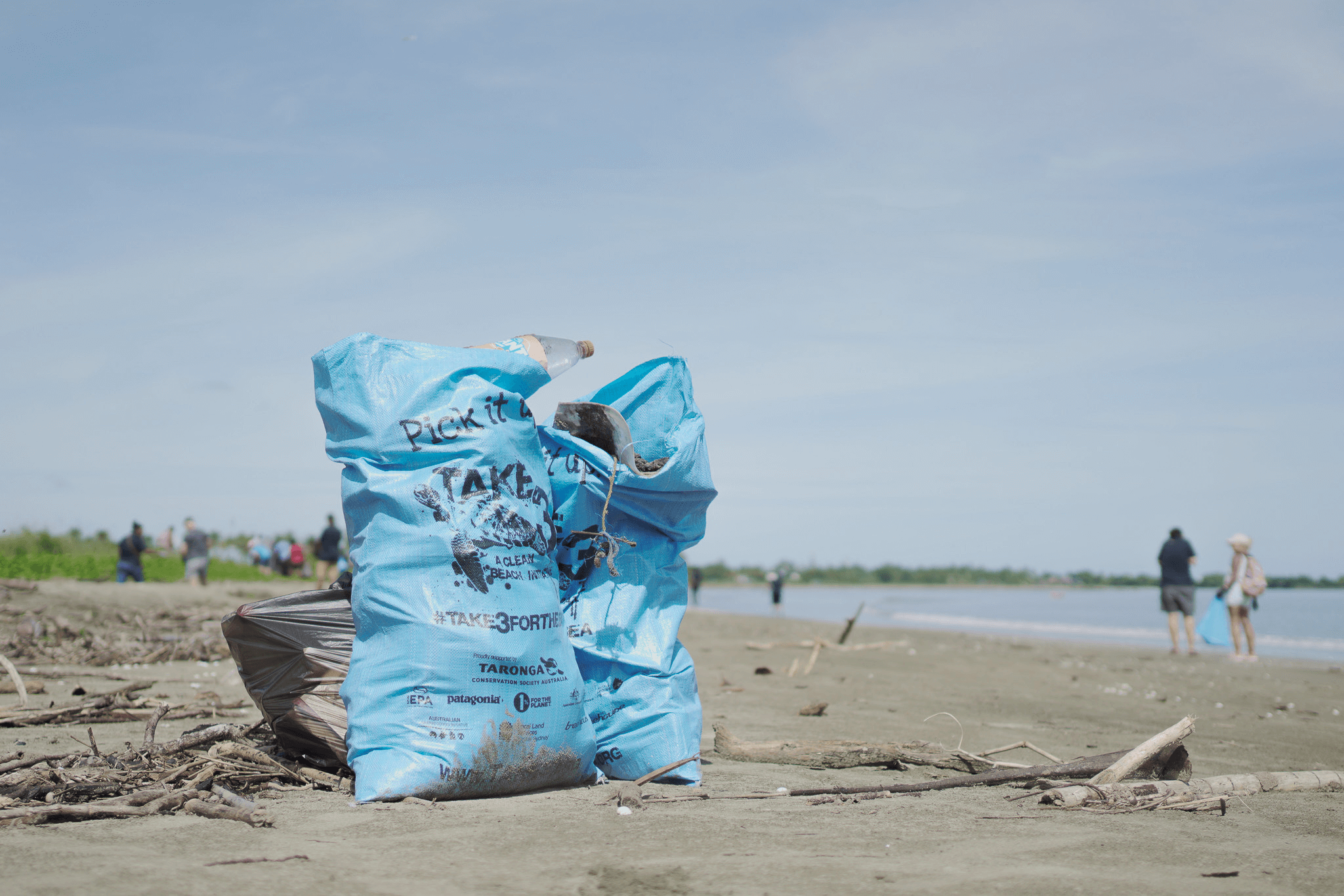 Blue Take 3 Fro the Sea rubblish bag full of plastic on a beach setting