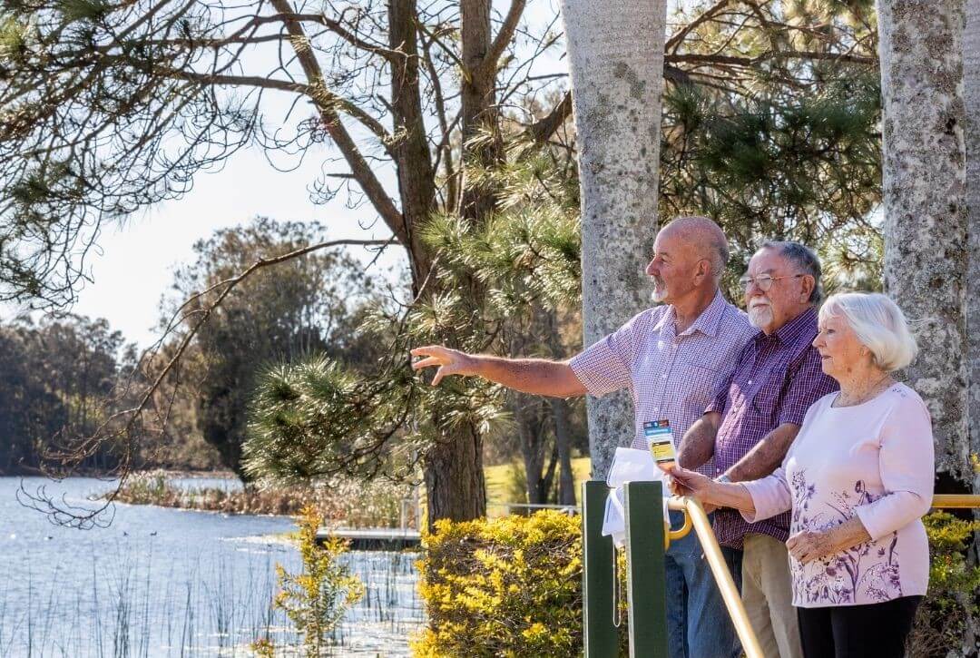 three people by the water assessing flood risk