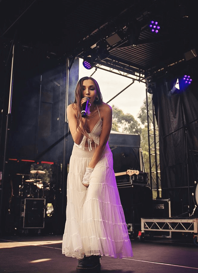 Singer Elaskia in white dress on stage