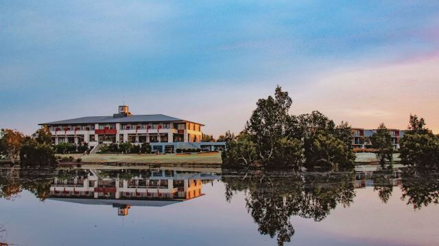 lakeside accommodation on a golf course at sunset