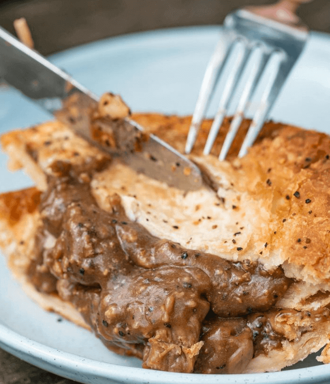 Beef pie on a plate being cut in half in Kulnura