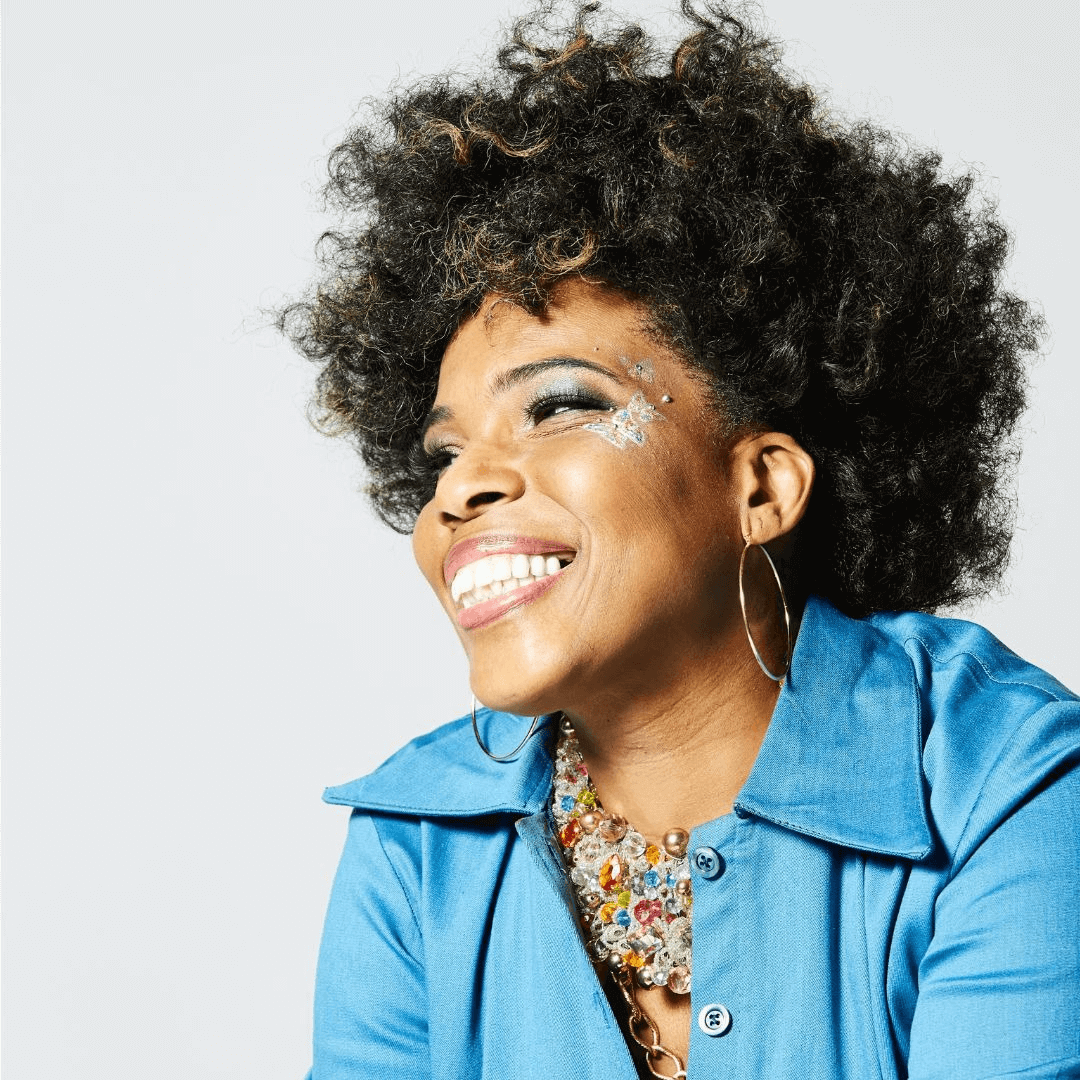 Singer Macy Grey wearing a blue dress and smiling 