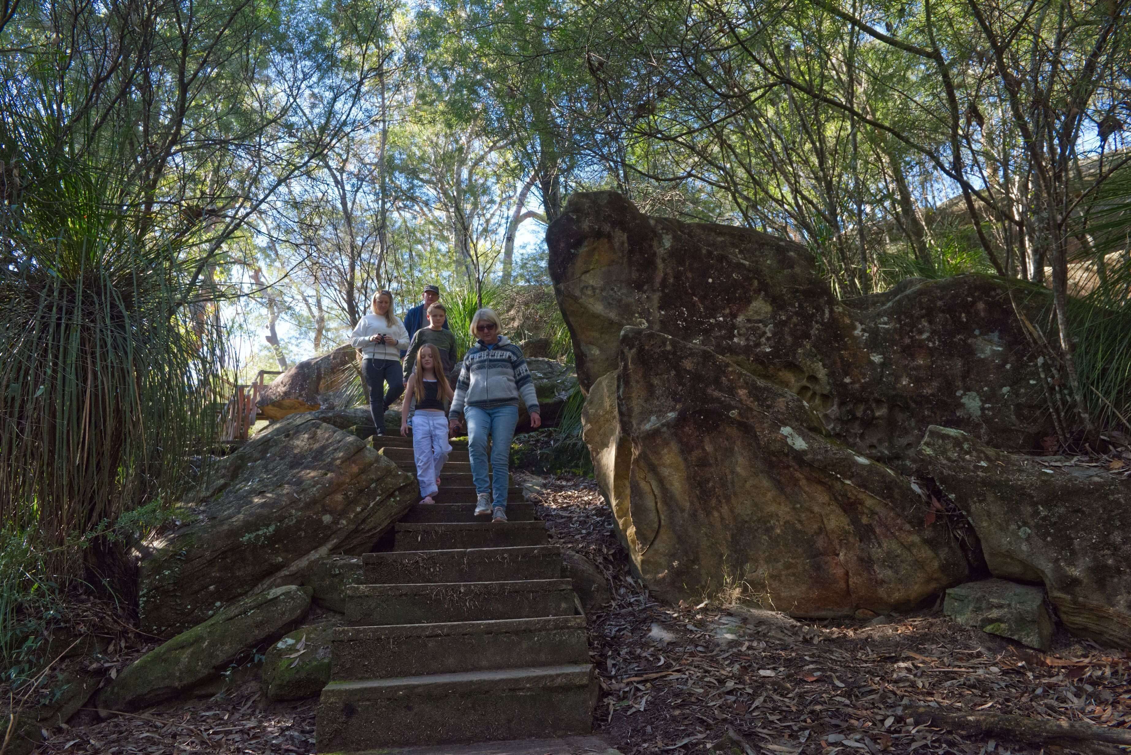 Family walking down stony staircase at Somersby Falls 