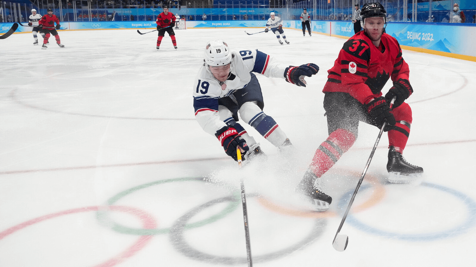 USA and Canada Ice hockey players skating towarrds the puk