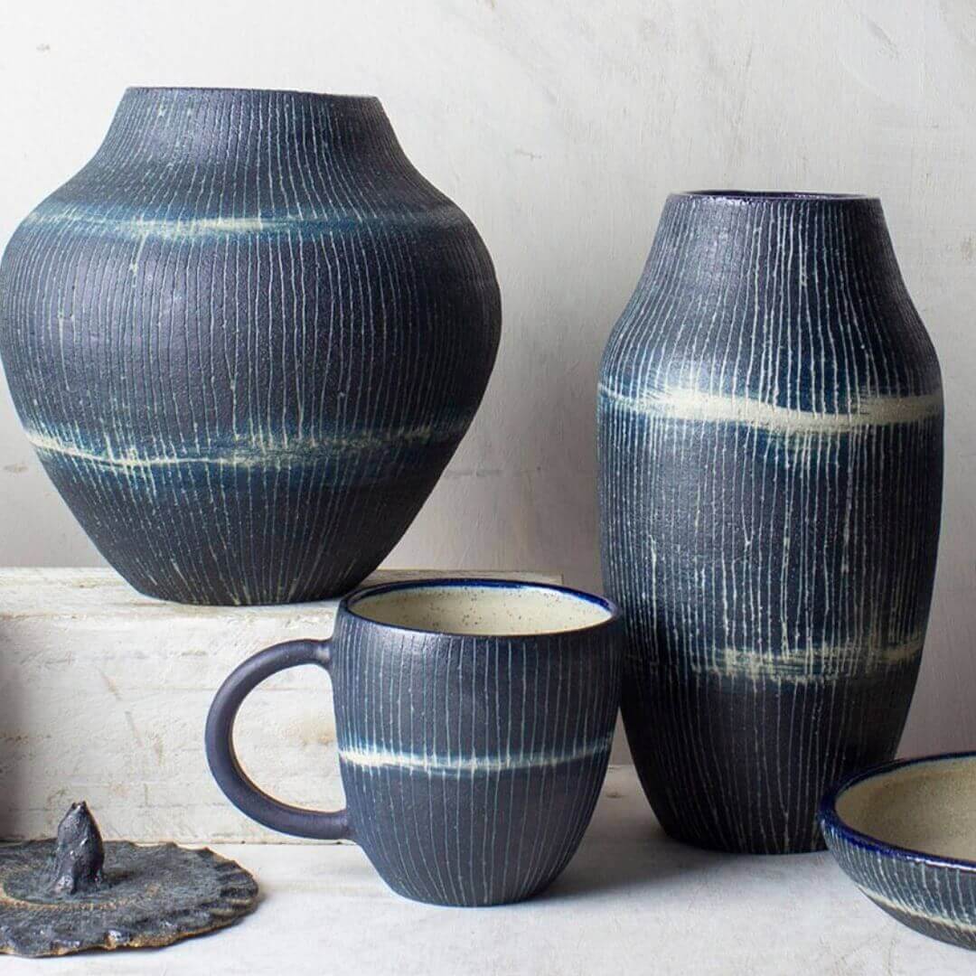 Display table with different levels showcasing deep blue pottery