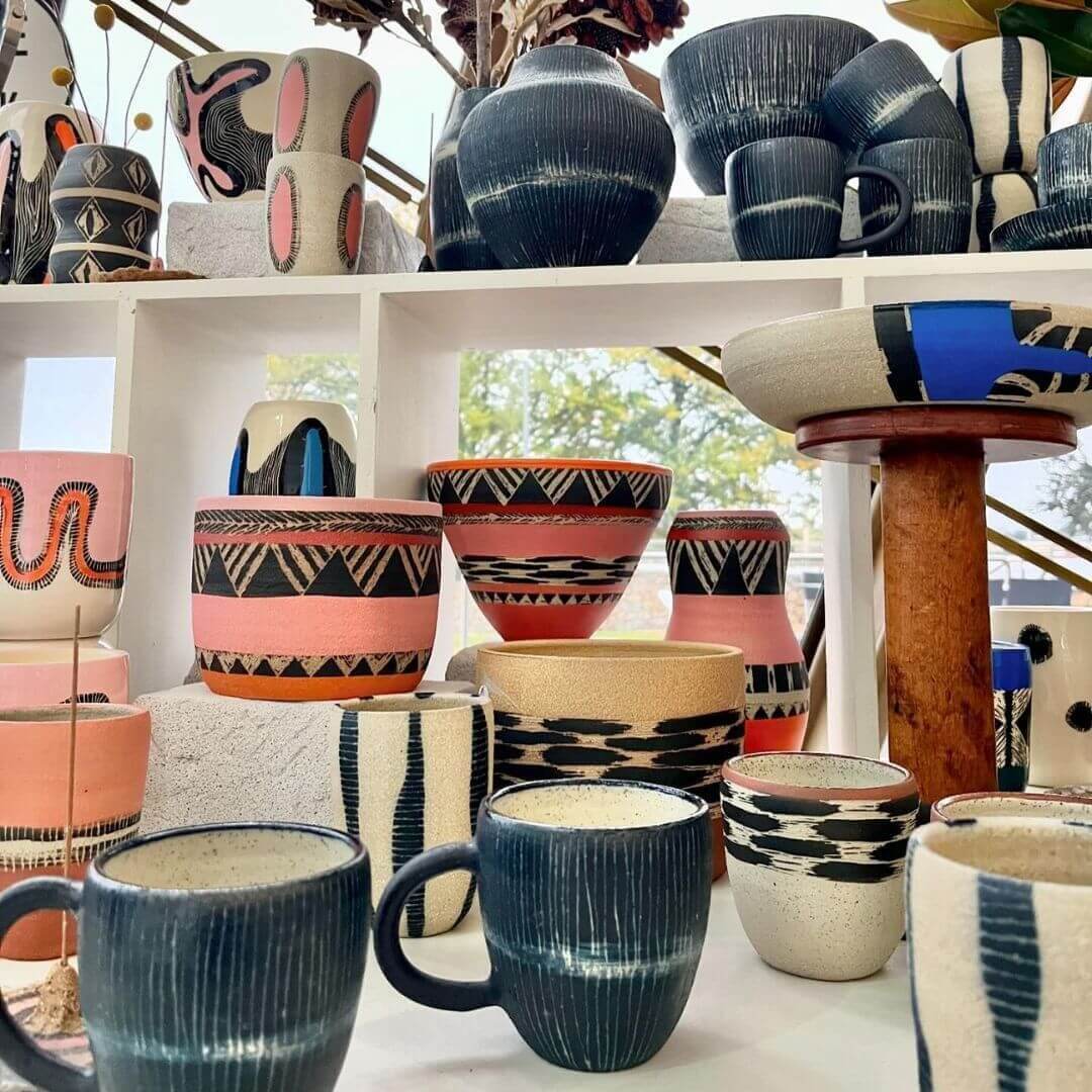 Display table with different levels showcasing different colour and shaped pottery