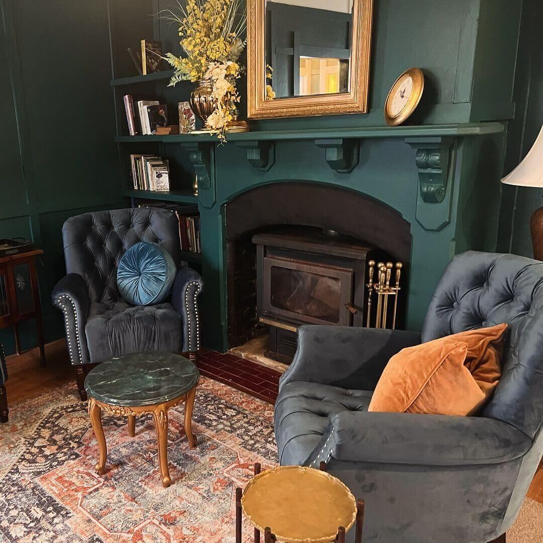 Cozy living room featuring charcoal chairs and a warm fireplace, creating a welcoming atmosphere for relaxation and gatherings.