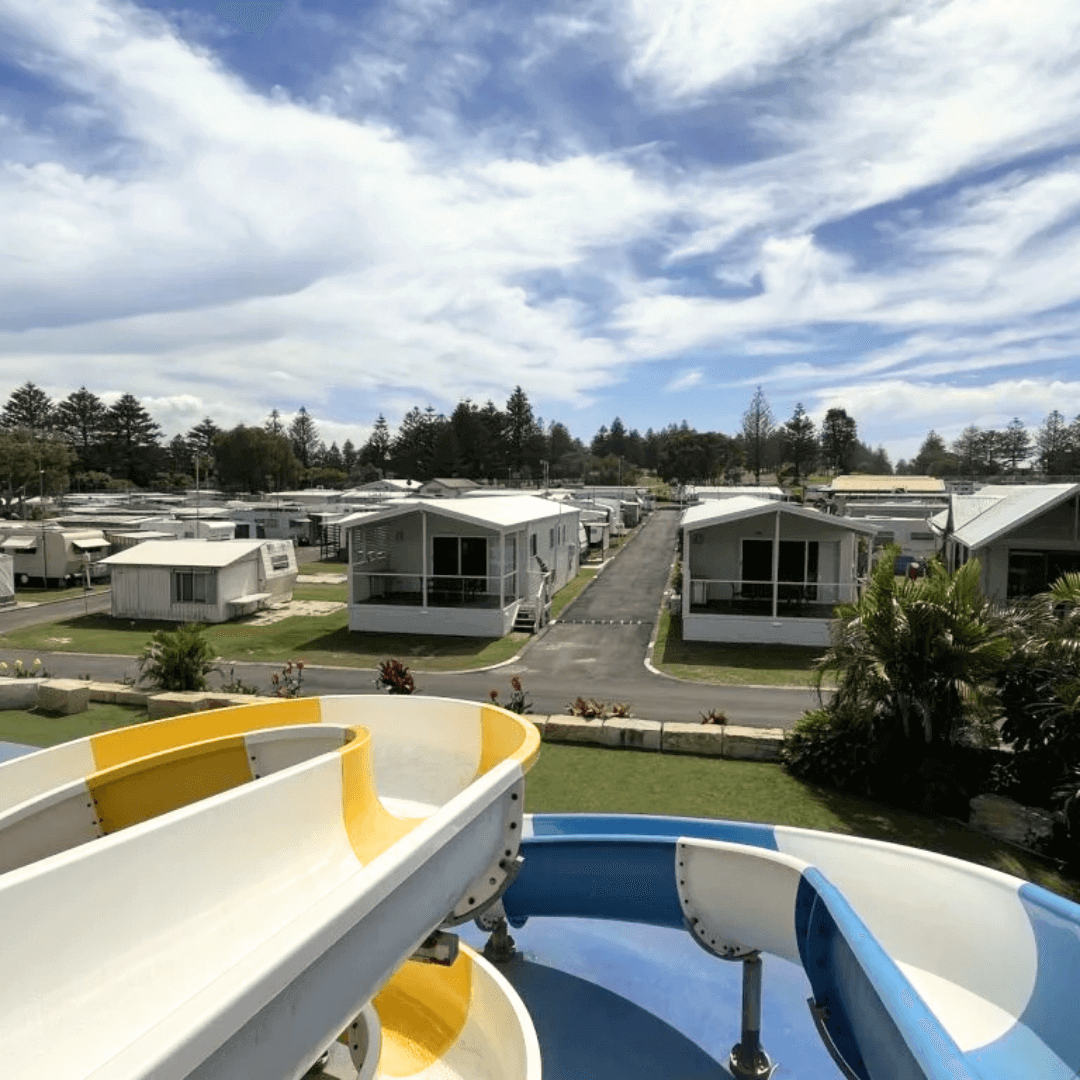 Point of view from water slide showing holiday cabins in the distance.