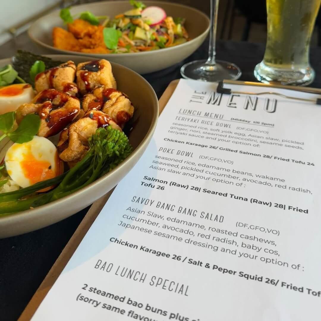 A clipboard featuring a menu with a wellness bowl filled with boiled egg, broccolini and tofu to the left of the menu