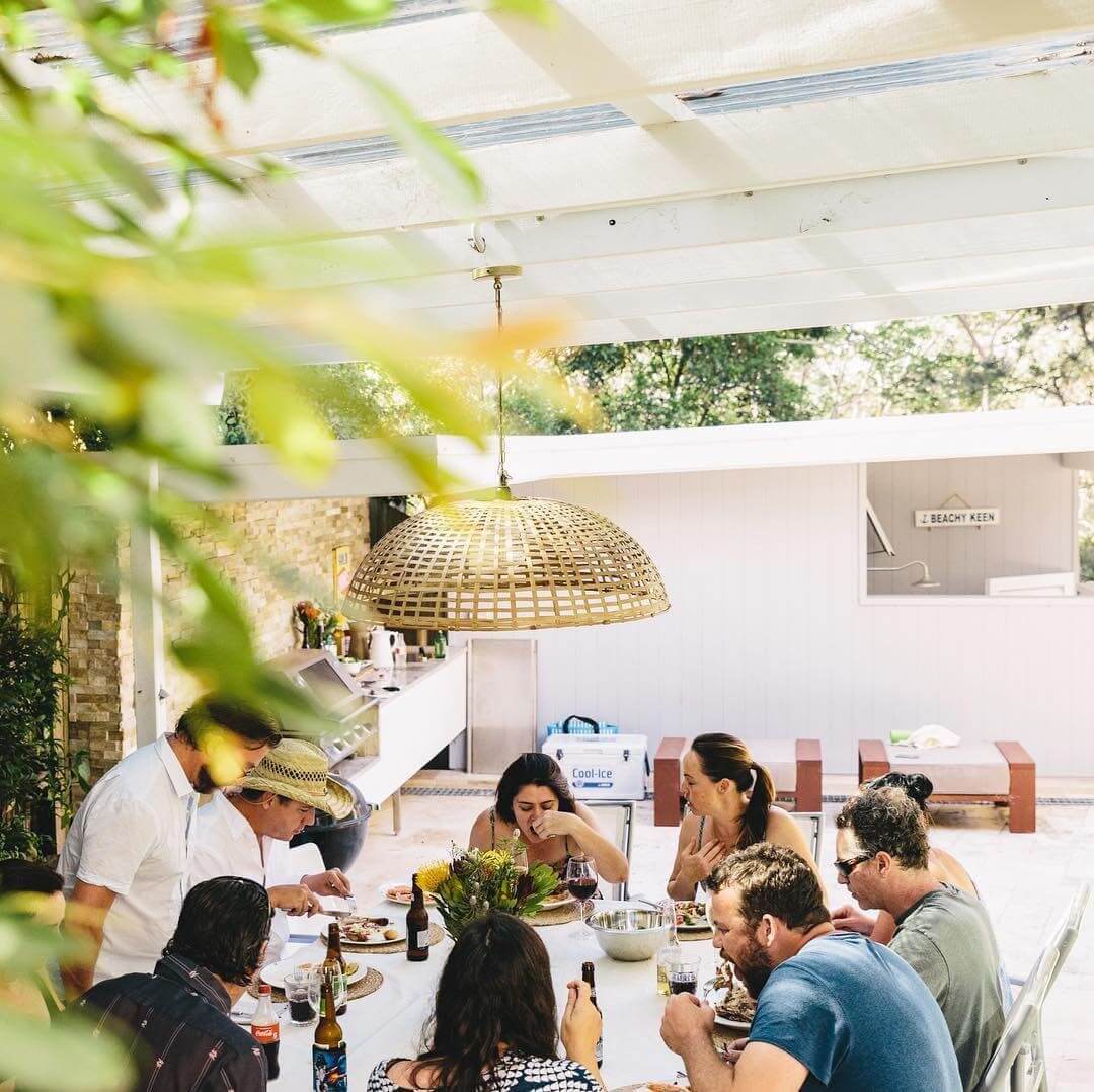 A group of friends sitting around an outdoor table eating