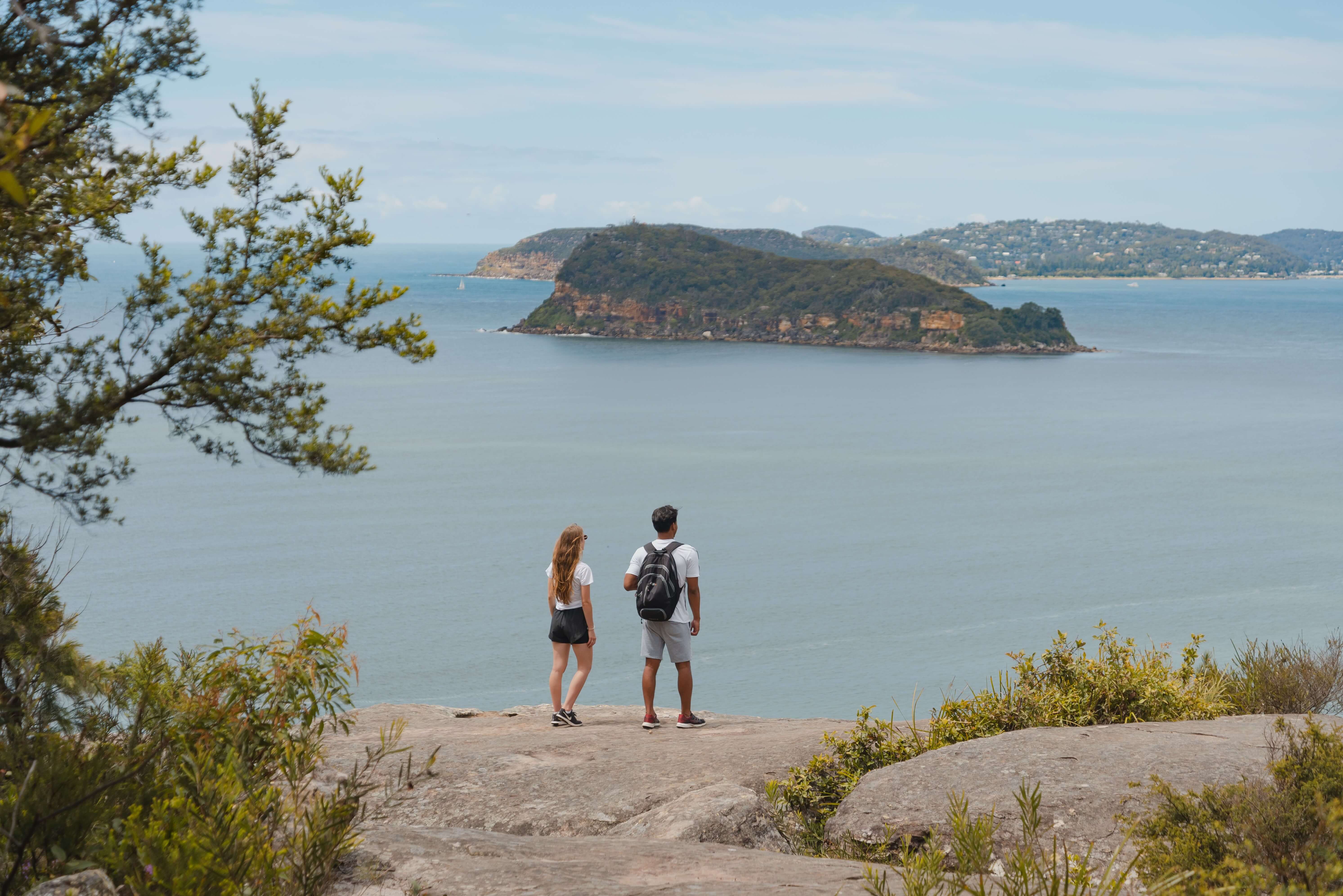 People at Bouddi national Park standing on edge of cliff