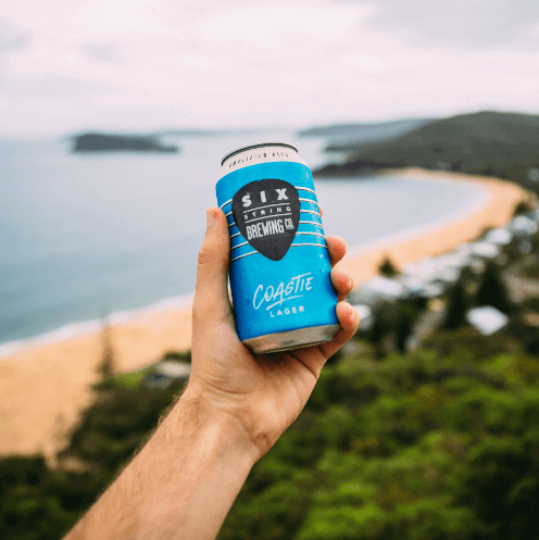 Can of lager being held up