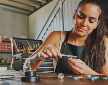 A focused woman meticulously crafting a beautiful piece of jewellery