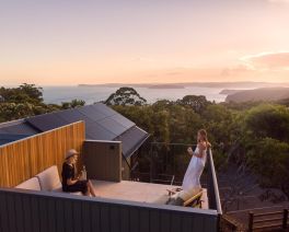 guests enjoy sunset on a lodge rooftop balcony with national park views