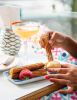 Churros being dipped into caramel dipping sauce Don Pedros