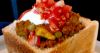 Bunny Chow, a half loaf of bread filled with curry, topped with Greek yoghurt and sambal