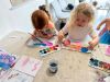 Two girls using water colours painting a picture