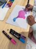 Children adding details using posca pens to their dinosaurs