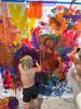 Child painting a large wall in warm colour paints