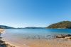 A lookout point from a beach with a mountain on the left and right covered in bushland